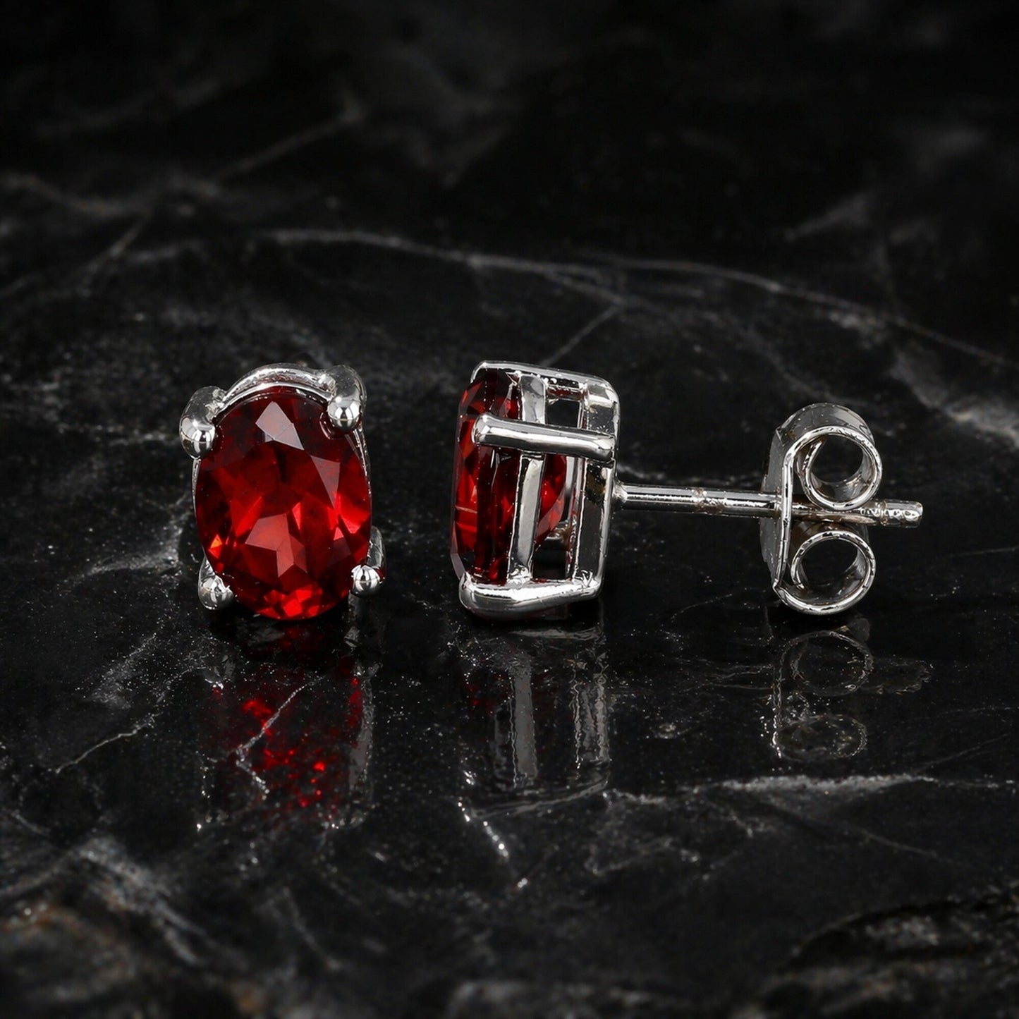 Side view of garnet dangle earrings with sterling silver bezel and post
