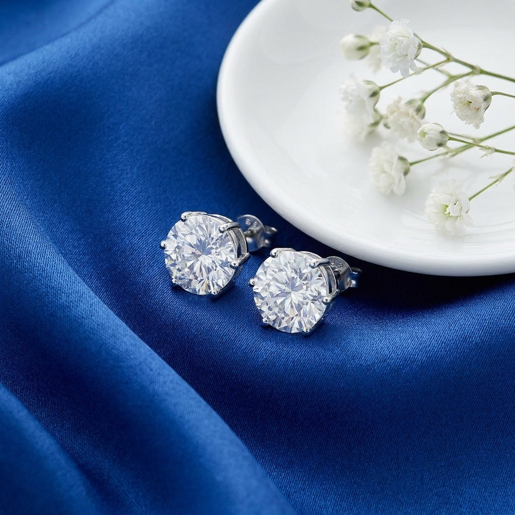 Round moissanite studs flat-lay with blue silk and pearls