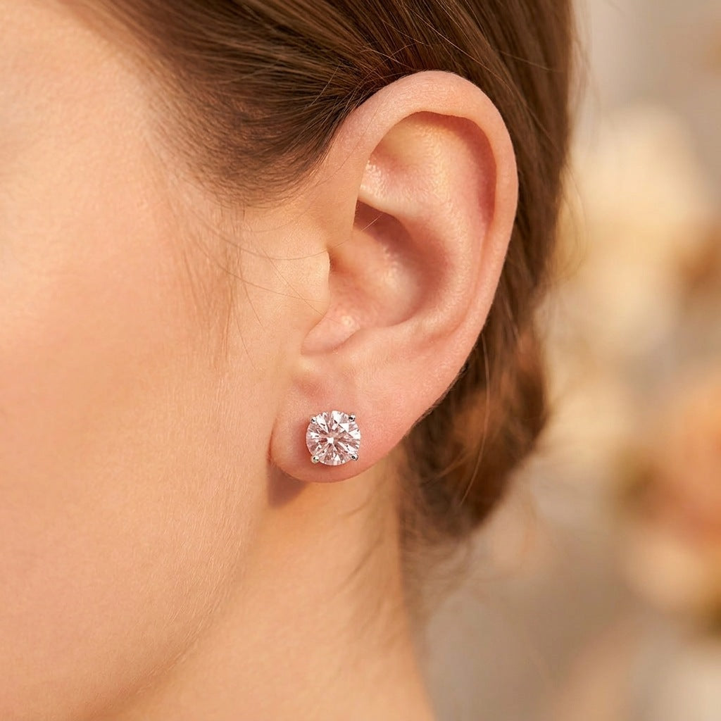 Close-up of round pale pink moissanite stud on earlobe
