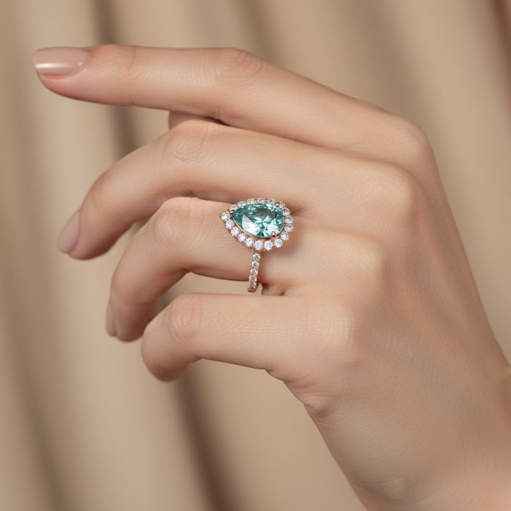 GEMHUB 4.70 Ct blue pear cut moissanite solitaire ring with diamond halo and band, set in gold vermeil.