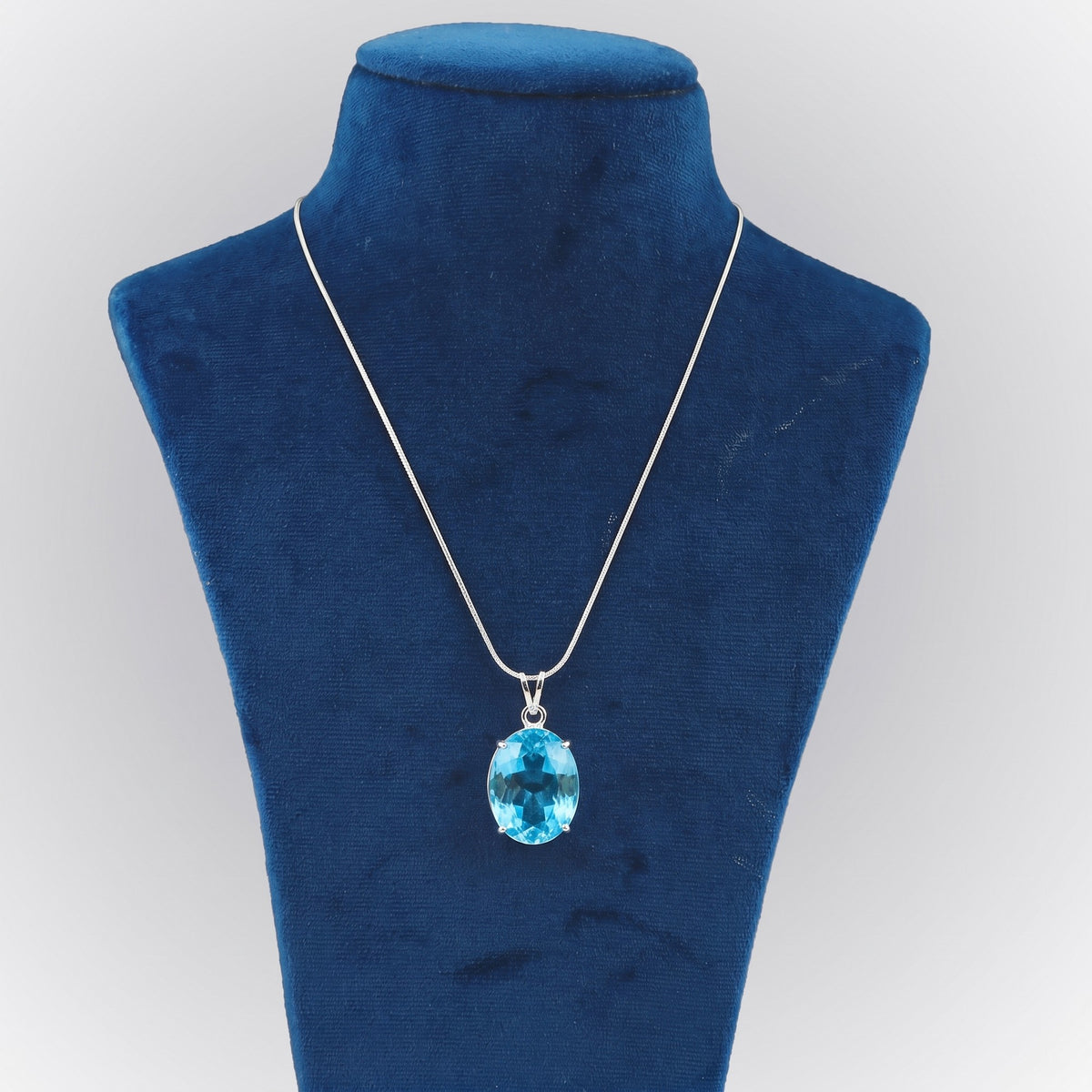 GEMHUB Swiss Blue Topaz Oval 44 Ct lab-grown gemstone pendant on display bust (AI render)