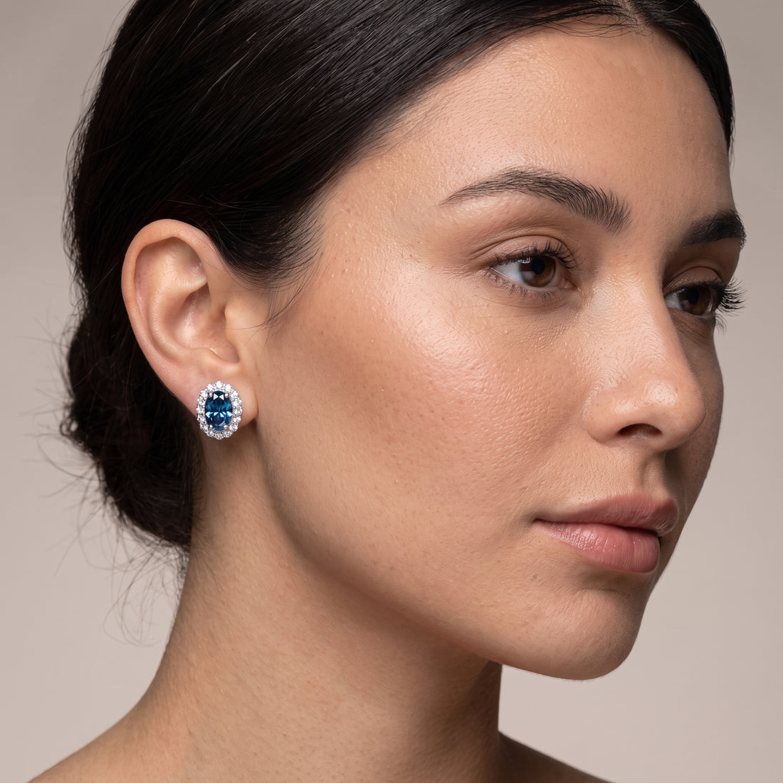 Model wearing 2.00ct DEW blue moissanite stud earrings in gold vermeil