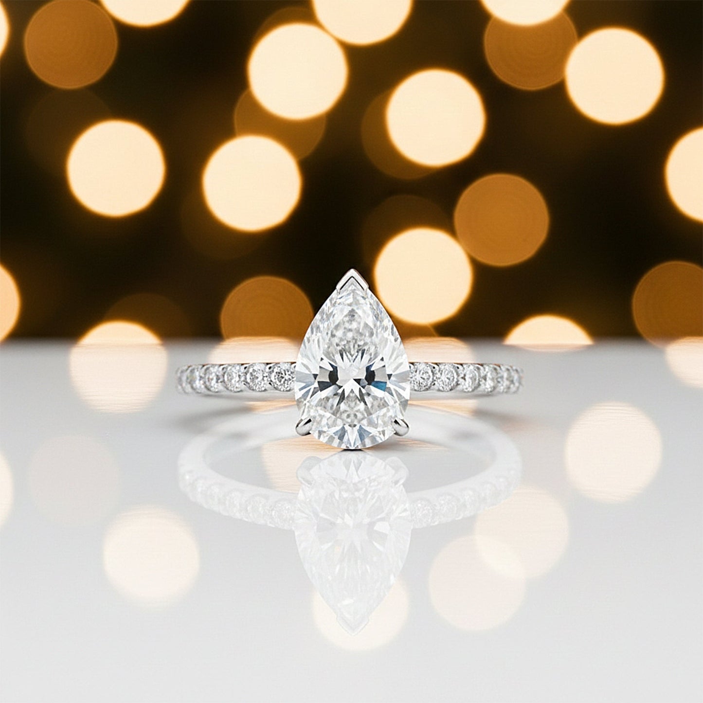 Detail of 18k gold vermeil prong holding tip of pear-cut diamond