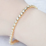 Bezel set diamond tennis bracelet worn on wrist, everyday refined styling