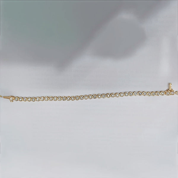 Underside of bezel tennis bracelet showing 14k yellow gold hallmark