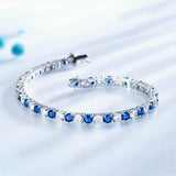 Top view of alternating blue sapphire and white diamond tennis bracelet