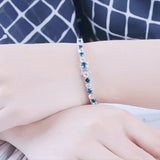 Sapphire diamond tennis bracelet worn on wrist, contrast styling for evening