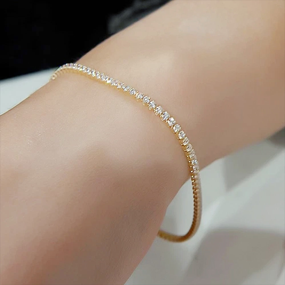 Detail of yellow gold clasp on natural diamond tennis bracelet