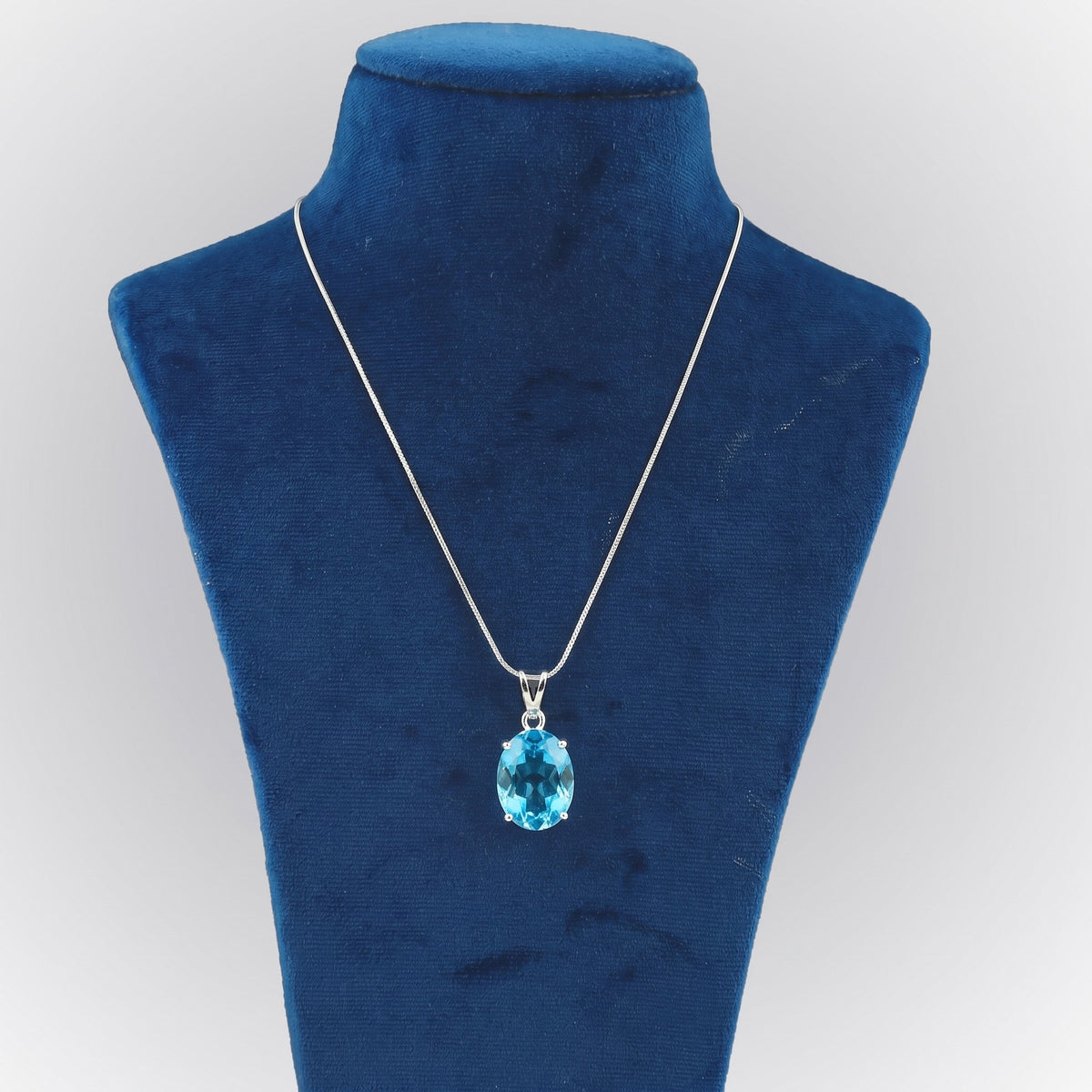 GEMHUB Blue Topaz Oval 135 Ct lab-grown gemstone pendant on display bust (AI render)