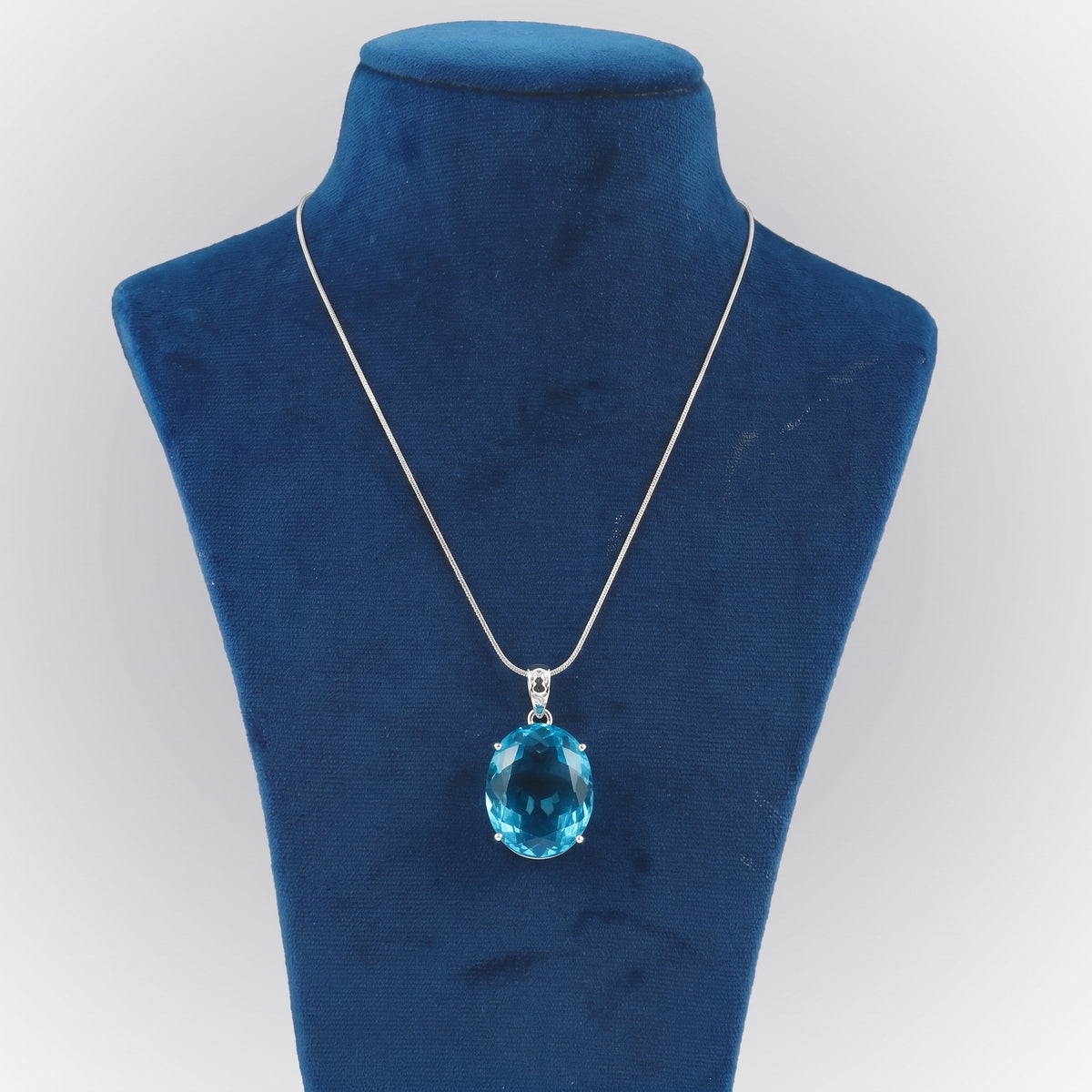 GEMHUB Blue Topaz Oval 88.5 Ct lab-grown gemstone pendant on display bust (AI render)