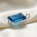 GEMHUB Blue Topaz Emerald 120 Ct pendant side view on silk (AI)
