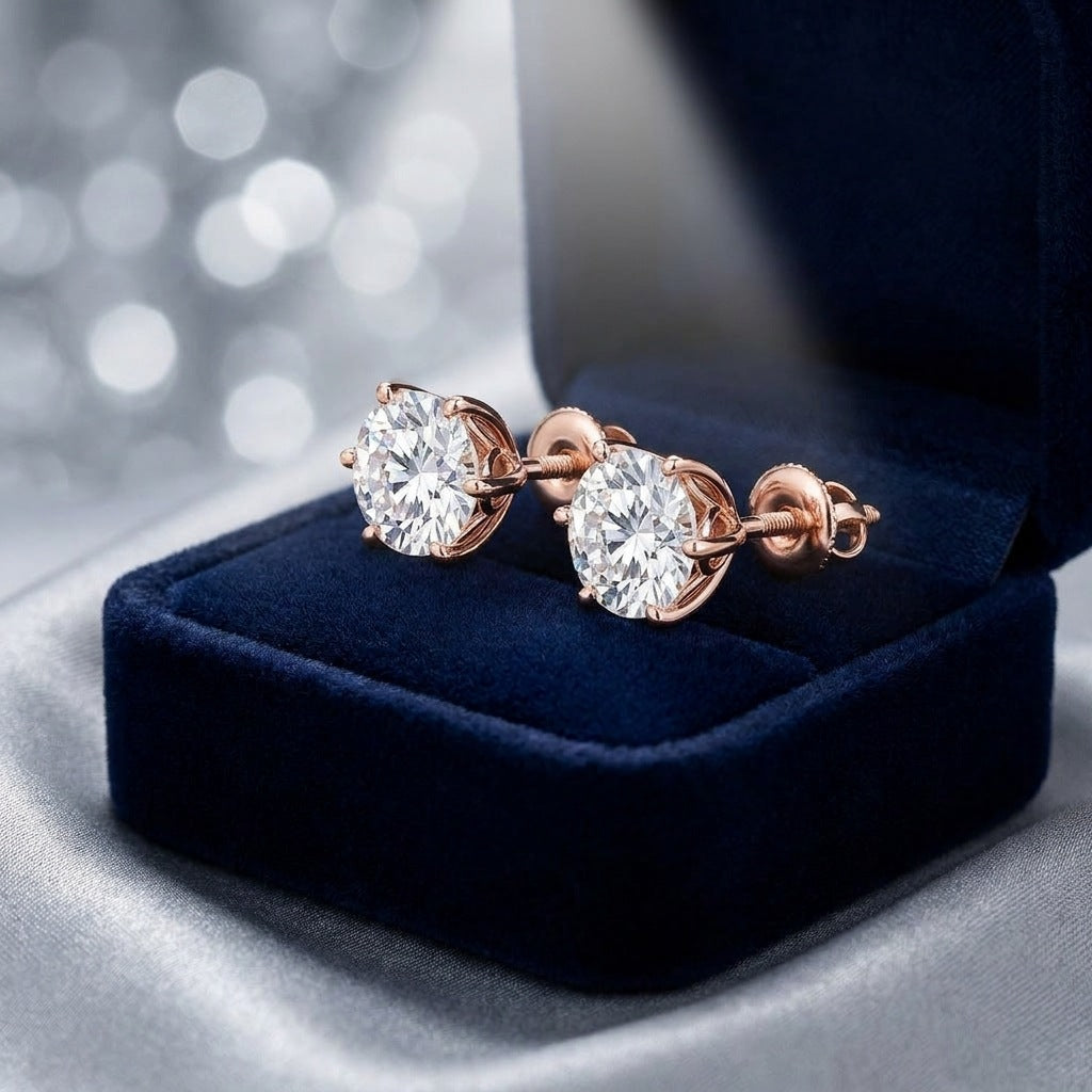 Pair of diamond solitaire studs in a navy velvet gift box