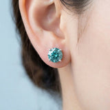 Close-up of teal blue moissanite stud on the earlobe