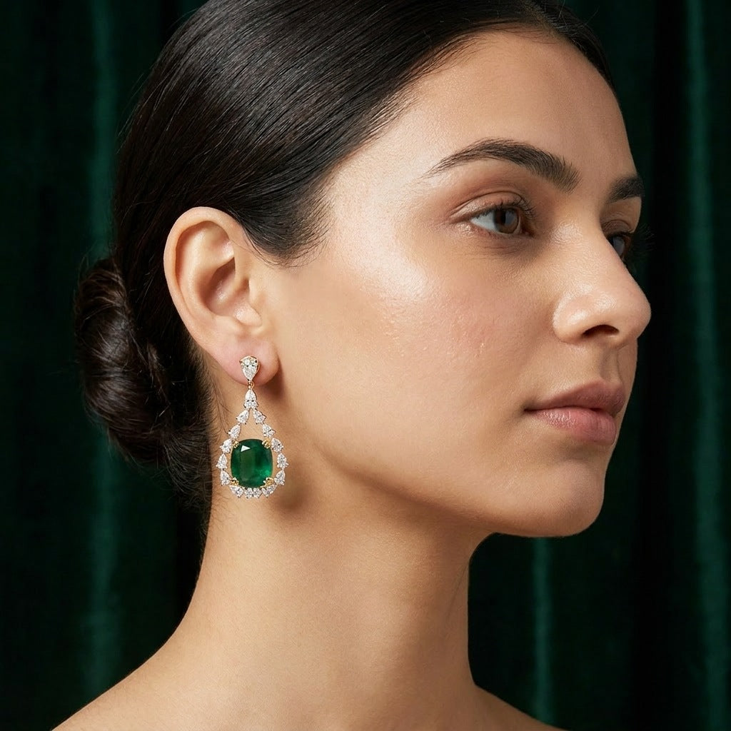 Emerald halo drop earring worn on the ear