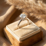 Round moissanite solitaire ring in a gift box on sand-toned linen