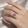 GEMHUB 1.3ct round pink moissanite solitaire ring with small accent stones on a silver band.