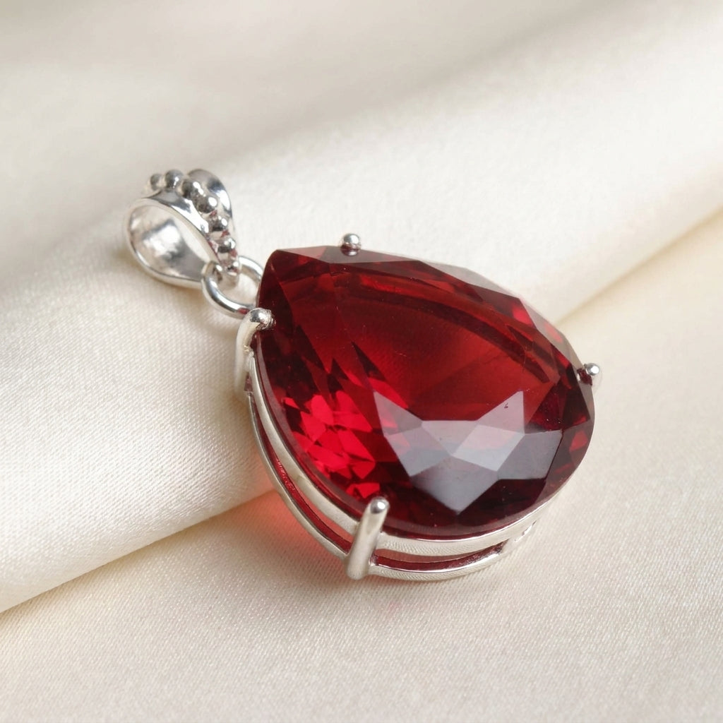 GEMHUB Red Topaz Pear 90 Ct pendant side view on silk (AI)